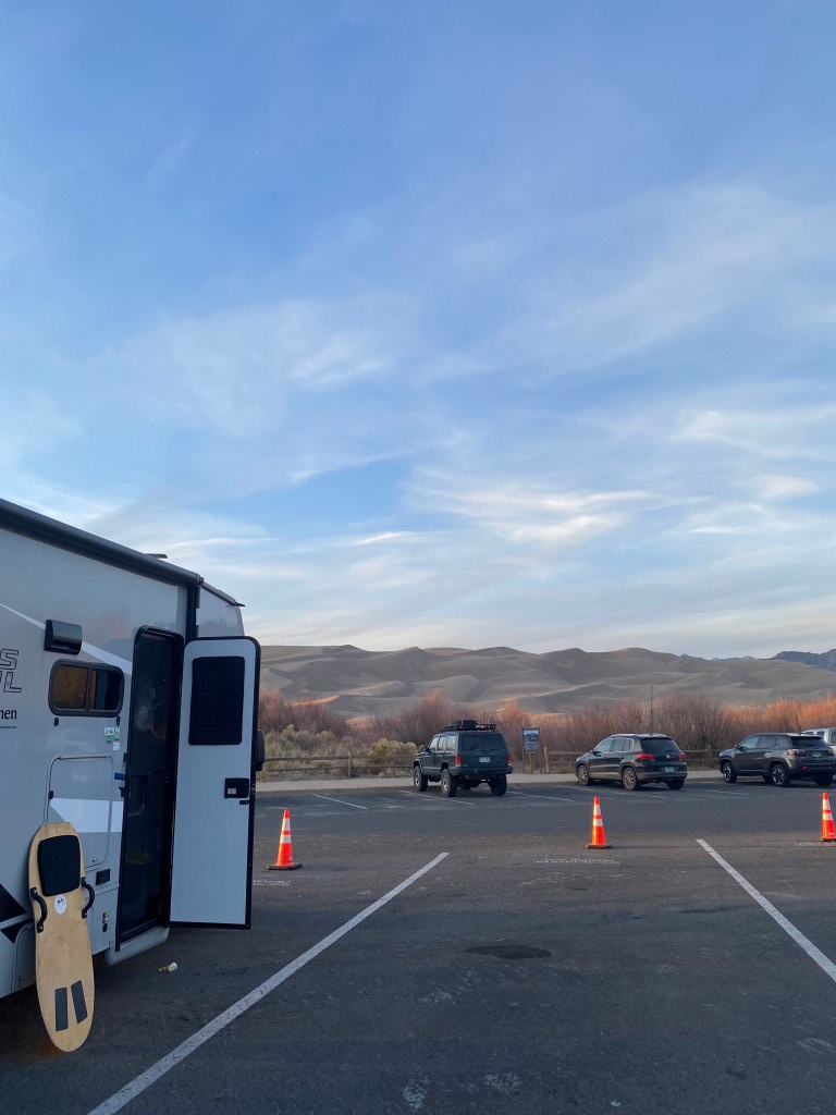 Our RV parked in front of the Great Sand Dunes in Colorado, van lifing it up.