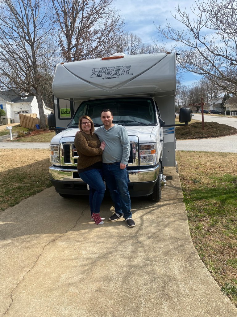 My girlfriend and I standing in front of our RV.