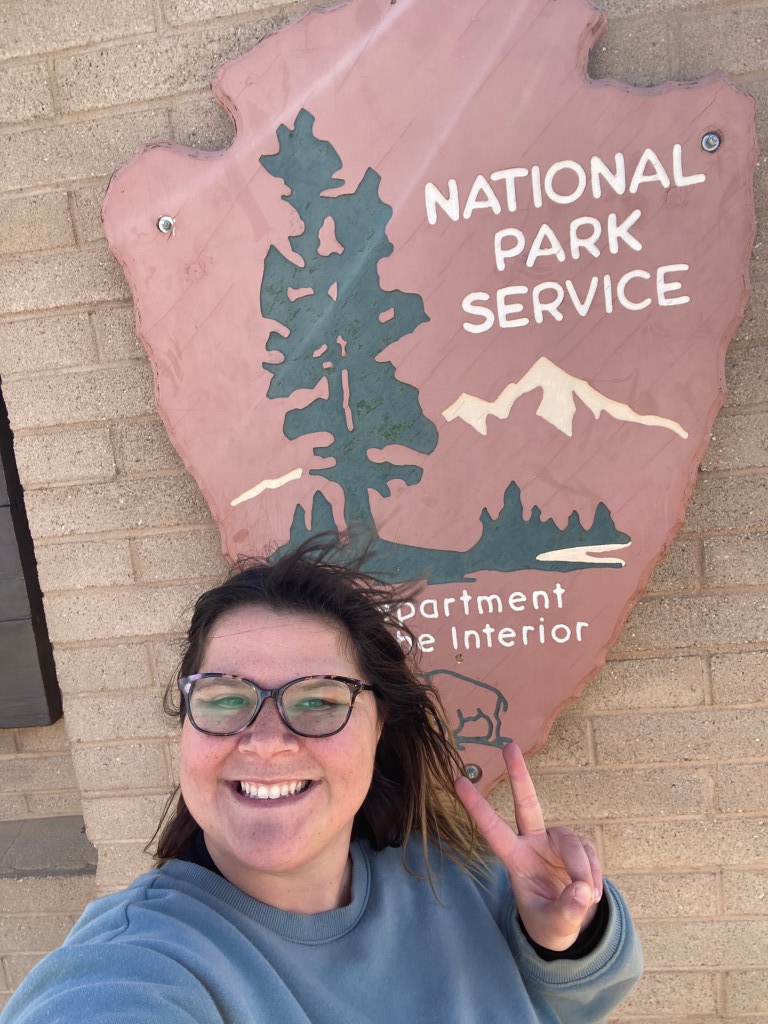 My girlfriend taking a selfie with the National Park Service sign.
